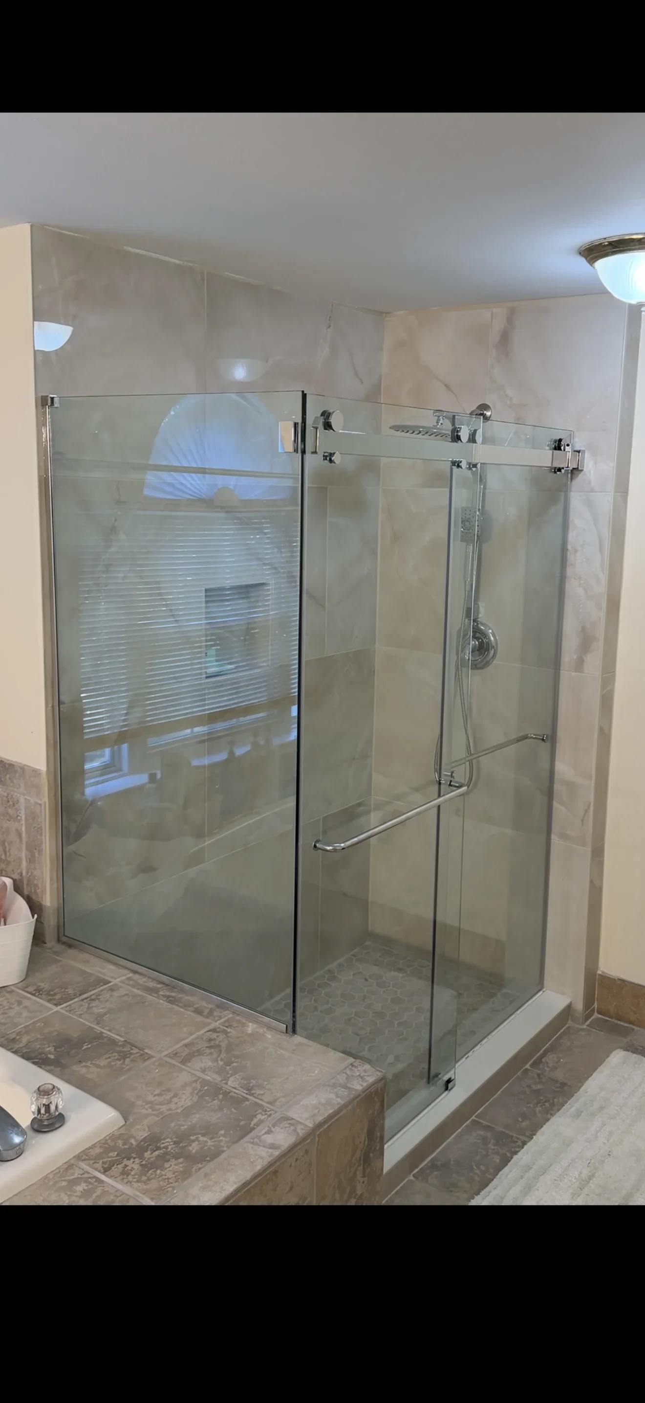 Frameless glass shower enclosure with chrome sliding doors and clear tempered glass panels